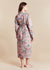 Woman wearing a lightweight floral robe against a beige background